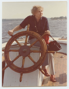Image of Elderly Miriam MacMillan at wheel or Schooner Bowdoin after renovation