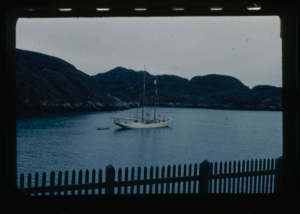 Image: The Bowdoin moored near mountain. Picket fence in foreground