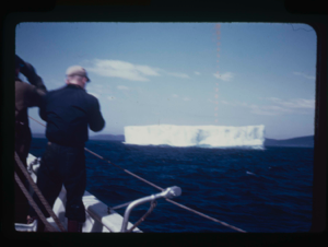 Image of Barney Turner on deck; iceberg beyond