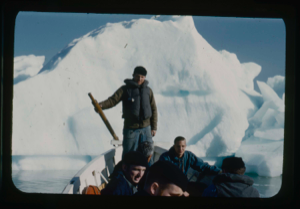Image of Crewmen in small boat by iceberg