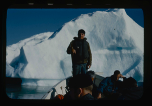 Image of Crewman in small boat by iceberg