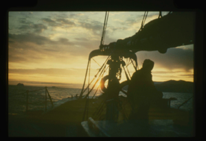 Image of Donald MacMillan at wheel, in sunset colours
