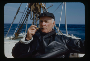 Image of Donald MacMillan sitting on deck with pipe (2 copies)