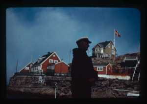 Image: Donald MacMillan aboard, looking at Sukkertoppen village (2 copies).