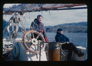 Image of Donald MacMillan sitting on deck, Miriam at wheel