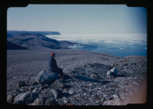 Image: Miriam MacMillan sitting on rock looking at ice pack (2 copies)
