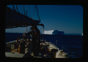 Image of Miriam MacMillan at wheel. Iceberg beyond (2 copies)