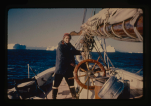 Image of Miriam MacMillan at wheel. Icebergs beyond (2 copies)