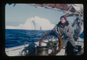 Image of Miriam MacMillan at wheel . Iceberg beyond.