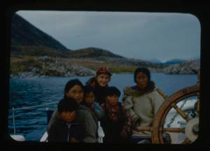Image of Inuit women and children with Miriam MacMillan by wheel
