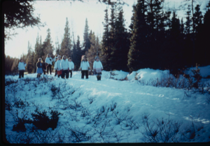 Image: Inuit women and children walking through snowy woods