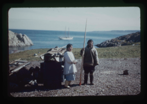 Image of Eskimo [Inuit] couple with narwhal tooth. The Bowdoin beyond.