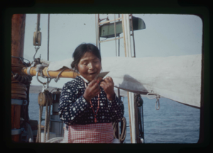 Image: Inawahoo, aboard, eating meat with ulu (2 copies)