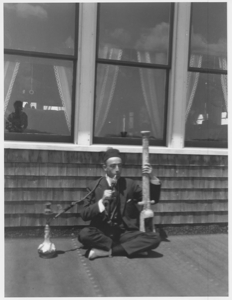 Image of Man seated cross legged on porch with Turkish pipe