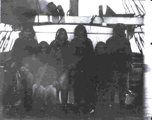 Image of 6 Inuit men aboard; one holding harpoon