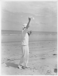 Image: Woman on beach, arm raised