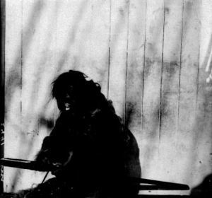 Image: Inuit man working on a tool (harpoon?)