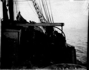 Image of Crewmen working on deck, one using camera