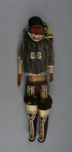 Image of Doll dressed in sealskin parka, leather-mosaic boots, baby in hood