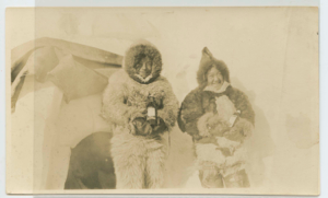 Image: A young man and woman by hatch-igloo of Bowdoin, displaying bottles of Hay's Lime and