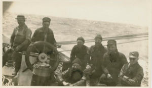 Image of Crew members by wheel. L>R: William Lewis, Richard Goddard, Donald Mix, Donald