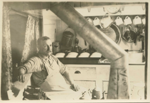 Image of William Lewis, cook, in the Bowdoin's galley. Bread is rising!