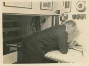 Image: Donald MacMillan in Bowdoin chart room, studying charts