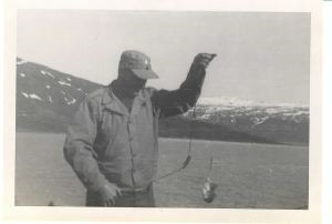 Image of Man holding up line with ? (not a fish) at end