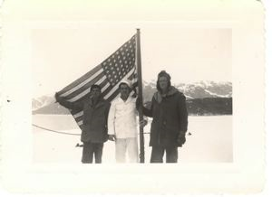Image of Three servicemen (one a chef) displaying American flag