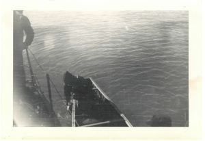 Image: Serviceman in canoe along-side ship