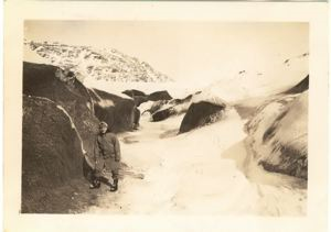 Image of Serviceman by rocks and snow