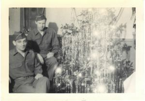 Image of Two servicemen by Christmas tree