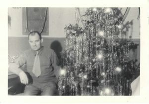 Image: Serviceman sitting by Christmas tree
