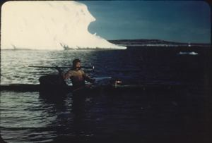 Image: Greenlander in kayak, harpoon poised. Iceberg near