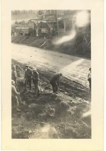 Image of Men working beside rough road