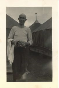 Image: Man with towel and toiletries, by tents