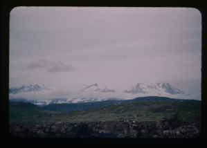 Image of Snow-covered mountains. Village(?) in foreground