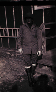 Image of Man in lace-up boots, possibly uniform, standing