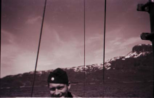 Image of Man on vessel, rigging and hills beyond