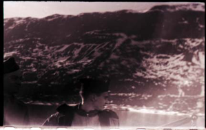 Image of Two men by rail watching approach to shoreline