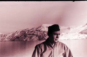 Image: Man standing by rail, mountains beyond