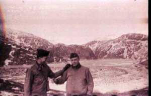 Image of Two men stand by ice-covered inlet