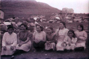 Image of Seven women and young girls kneel in a row