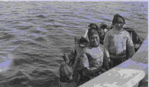 Image of Eskimo women and children arrive by boat