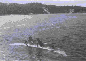 Image of Three crewmen on dory submerged on its side