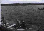 Image of Two dories in water. Crew in foul weather gear