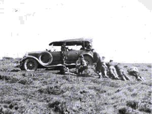 Image of Men resting by touring car
