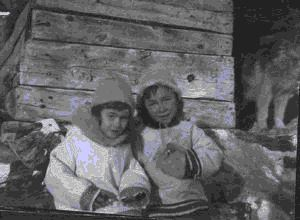 Image of Two Eskimo [Inuit] girls sitting in a barn