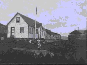 Image of School buildings, children in front