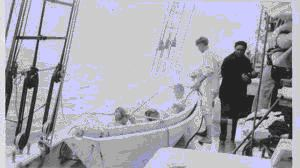 Image: Bath time in dory, aboard. Two crewmen near, one in union suit